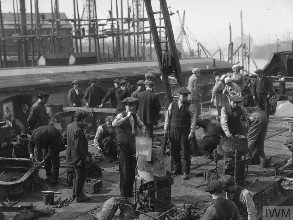 © IWM (Q 20002) Workers beginning on the ship 'skeleton', which can be seen in the background, at Harland and Wolff shipbuilding yard, Clydebrae Street, Govan, Glasgow.