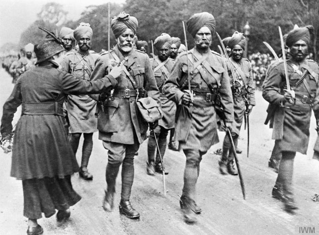 During a march past of Indian troops, a woman pins flowers on to the tunic of one of the soldiers.