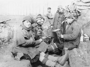 2nd Battalion Argyll and Sutherland Highlanders, 19th Brigade, 6th and 27th Division, Bois Grenier Sector, March-June 1915. Men in the support line smoking and playing the accordion. © IWM (Q 48944)
