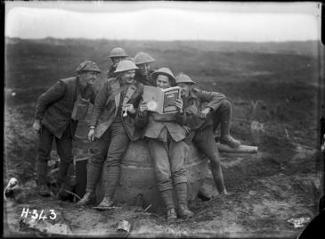 World War I New Zealand soldiers with a copy of 'New Zealand at the Front'. Royal New Zealand Returned and Services' Association :New Zealand official negatives, World War 1914-1918. Ref: 1/2-012980-G. Alexander Turnbull Library, Wellington, New Zealand. /records/22539048