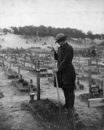 The grave of Betty Stevenson is tended to by a member of the Women's Army Auxiliary Corps (WAAC) in a graveyard at Etaples, France.