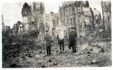 Three British soldiers posing in front of the ruins of the Town Hall on the Market Square in Ypres, December 1914. (In Flanders Fields Museum)  