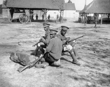 © IWM (Q 1201) Troops of the West Indies Regiment cleaning their rifles on the Albert - Amiens road, September 1916.