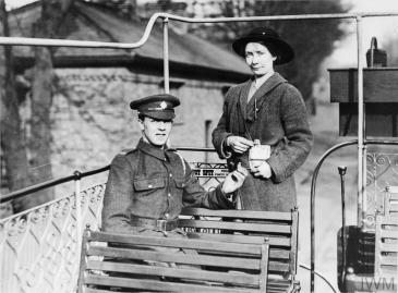 A female tram conductor of the LUR Tramway Company issues a ticket to a British soldier on an open top tram. © IWM (Q 109772)